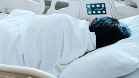 Uma pessoa deitada em leito de hospital