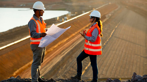 Dois trabalhadores fazendo a fiscalização de uma barragem.