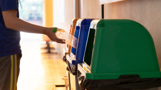 Homem jogando garrafa em lixeira