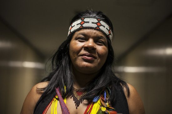 A imagem mostra Sonia vestida de adereços indígenas sorrindo para foto.