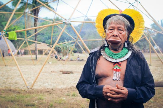 A imagem mostra o Cacique Raoni em sua aldeia.